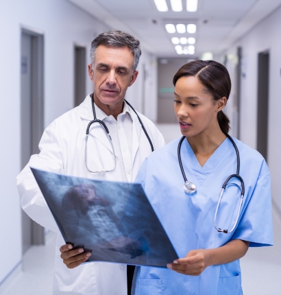Two doctors examining an X-ray in a corridor